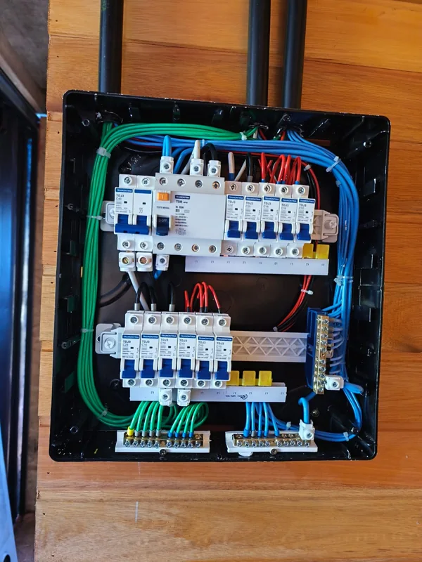Quadro de distribuição com duas fileiras de disjuntores e condutores organizados