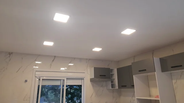 Painéis de luz e pontos de iluminação no teto de uma cozinha.