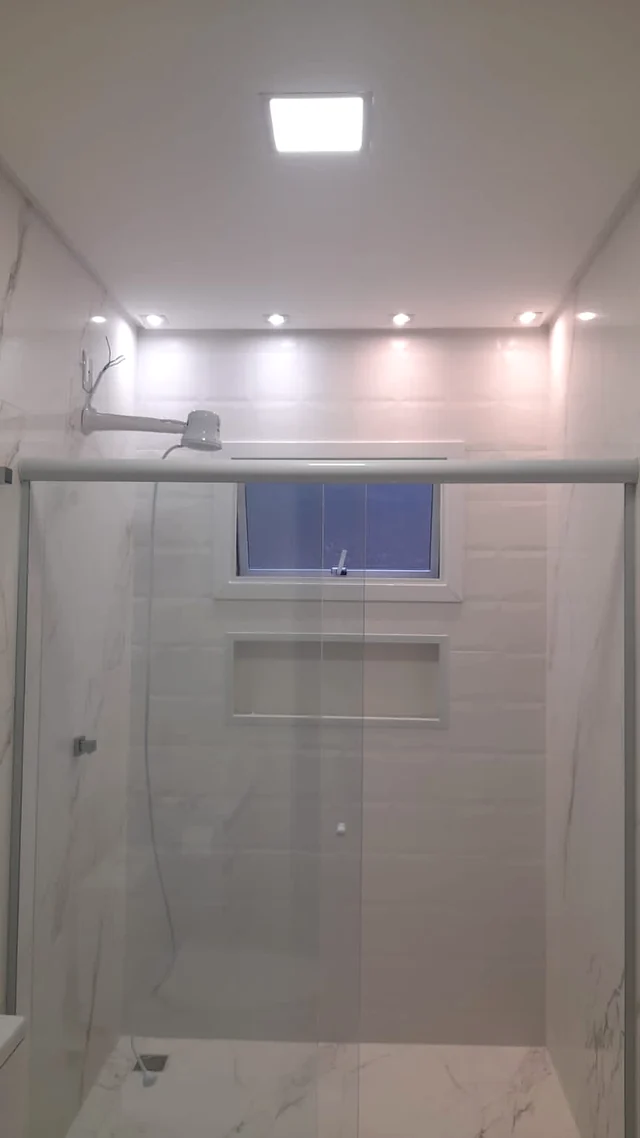 Painel de luz central e pequenos pontos de luz em um banheiro.
