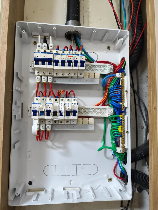 Depois do serviço: o mesmo quadro elétrico com duas fileiras de disjuntores e fiação organizada.